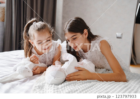 Newborn baby with his sisters in a white dress Newborn baby with his sisters in a white dress 123797933