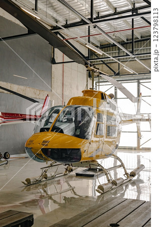 Yellow tourist helicopter in hangar 123798113
