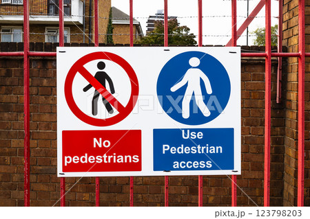 No Pedestrians and Use Pedestrian Access Safety Sign on a Red Fence 123798203