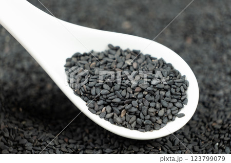 Natural black sesame grains in a spoon macro close-up 123799079