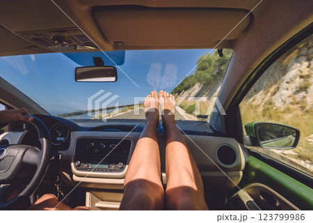 Woman Sitting in Car with Bare Feet on Dashboard 123799986