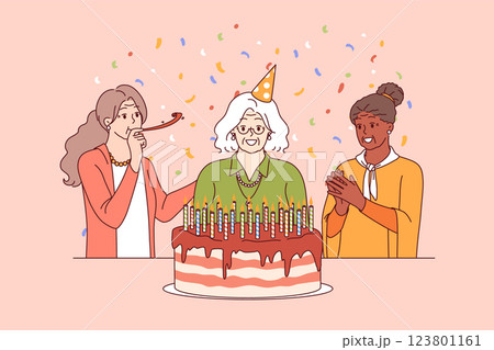 Birthday of elderly woman standing near large cake with candles and happy friends 123801161