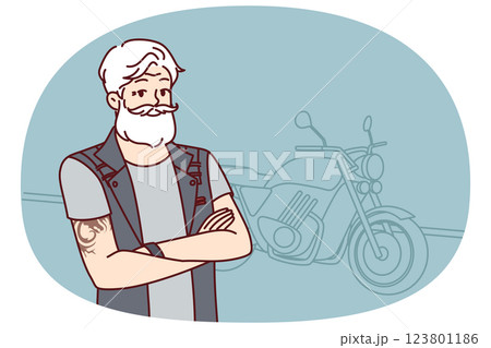 Old biker near motorcycle with tattoo on arms and gray hair wishes to travel after retirement 123801186