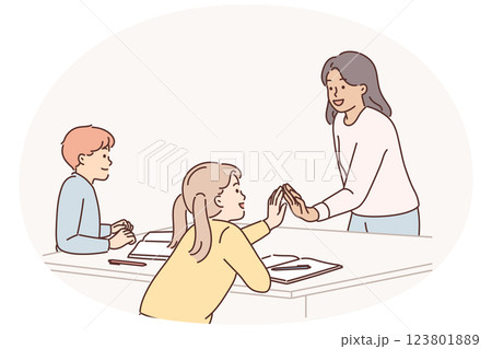 Woman teacher gives high-five to girl who is elementary school or kindergarten student Woman teacher gives high-five to girl who is elementary school or kindergarten student 123801889