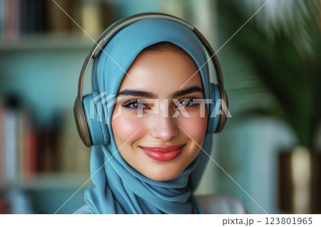A clean and minimalistic portrait of a smiling Arabian girl wearing headphones, set against a soft mint background, exuding serenity, modernity, and youthful elegance, passion for music or studies 123801965