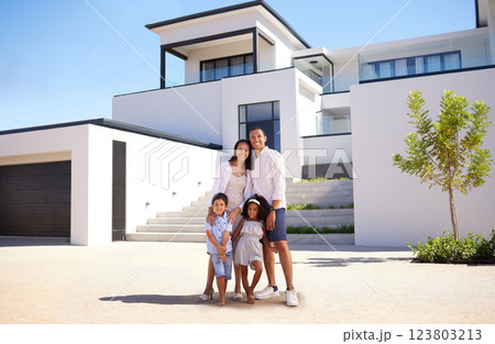 Portrait, real estate and happy family moving into their new luxury home, house or property in summer. Happy parents and children standing with a smile outdoor with building investment or purchase 123803213