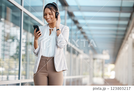 Phone, business and woman streaming music online in headphones listening to radio, podcast or audio sound. Smile, office and happy employee playing a song on subscription playlist on a break at work Phone, business and woman streaming music online in headphones listening to radio, podcast or audio sound. Smile, office and happy employee playing a song on subscription playlist on a break at work 123803217
