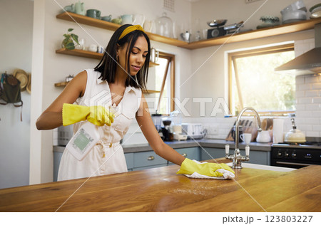 Cleaning, kitchen and housework with a woman cleaner working to keep her house hygienic and fresh. Clean, sanitize and hygiene with a female using detergent or disinfectant to wash and wipe a surface 123803227