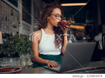 Coffee, laptop and freelance with a woman entrepreneur doing remote work from an internet cafe. Computer, email and small business with a female working on a report, email or proposal in a restaurant 123803474