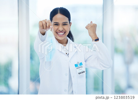 Doctor, happy and celebration with mask off face for end of covid 19, pandemic and coronavirus. Woman, medic and smile in hospital, clinic or healthcare cheering for stop of virus, bacteria or germs 123803519