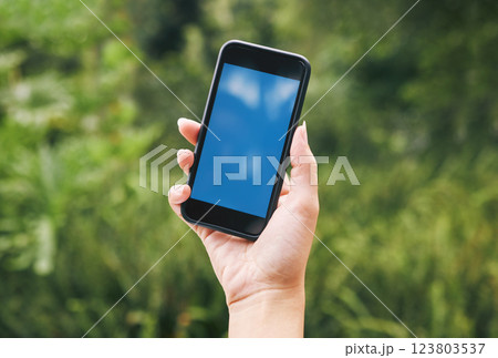Nature, hand of woman with phone and mockup or green screen, contact us outside. Outdoor plants, leaves in background and smartphone in hands with 5g wifi internet connection and business information 123803537