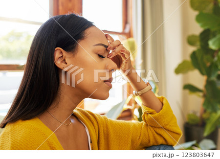 Stressed woman, headache and burnout with mental health issues at home in the living room. Female in depression alone holding head feeling anxious, depressed and frustrated at the house 123803647