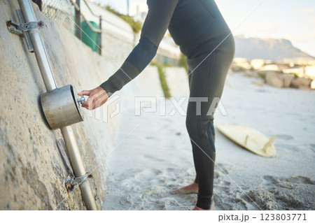 Beach, surfer man and shower after surfing by ocean to clean surfboard on holiday, vacation or summer trip. Surf, washing and hygiene of male at sandy seashore in Canada for water sports or exercise. 123803771