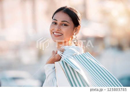 Woman, retail shopping bag and city travel for discount sales, market and fashion promotion in urban Dubai UAE. Portrait of happy, rich wealth and smile young arab girl customer buying luxury outdoor 123803785