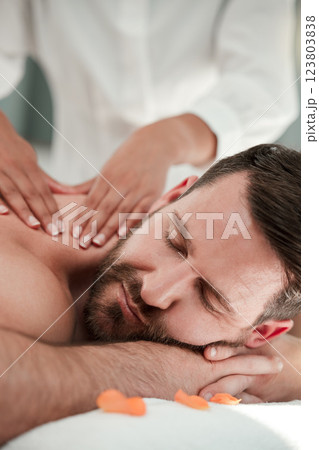 Zen spa, man and shoulder massage in luxury healthcare clinic, wellness beauty salon or peace room for relax sleep on table bed. Zoom, people or cosmetic therapist or masseuse oil hands for self care Zen spa, man and shoulder massage in luxury healthcare clinic, wellness beauty salon or peace room for relax sleep on table bed. Zoom, people or cosmetic therapist or masseuse oil hands for self care 123803838