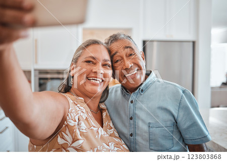 Selfie, senior couple and happy in kitchen at home being romantic, fun and smile together for anniversary. Retirement, elderly man and woman being loving, bonding or relax indoors for love or romance 123803868