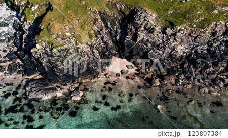 Aerial drone shot above a rocky, secret sandy beach with clear water Aerial drone shot above a rocky, secret sandy beach with clear water 123807384