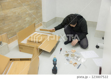 たくさんのパーツの組み立て家具を組み立てる男性 たくさんのパーツの組み立て家具を組み立てる男性 123807522