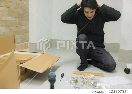 たくさんのパーツの組み立て家具を組み立てる男性 たくさんのパーツの組み立て家具を組み立てる男性 123807524