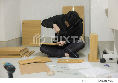 たくさんのパーツの組み立て家具を組み立てる男性 たくさんのパーツの組み立て家具を組み立てる男性 123807531