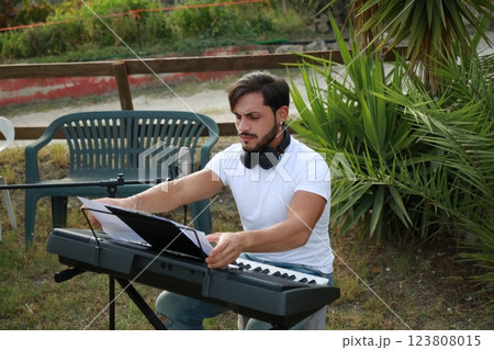 Boy Pianist Plays The Keyboard In An Outdoor Garden For A Private Party 123808015