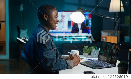 Smiling employee saluting managers, using online videocall to ask for feedback on project progress. Cheerful worker waving hand, greeting coworkers in teleconference meeting, camera A 123808019