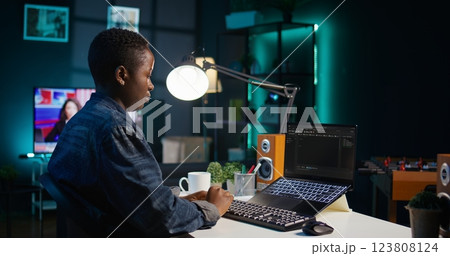 Software developer writes code on laptop screen while in apartment office using Java programming languages. Programmer remotely working on fixing database errors while working from home, camera B Software developer writes code on laptop screen while in apartment office using Java programming languages. Programmer remotely working on fixing database errors while working from home, camera B 123808124