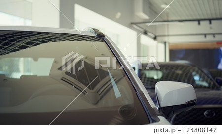 Exterior detail close up of steel white car body door post, windows, and driver chair inside. Panning shot of parked vehicle and leather black seat in automobile interior Exterior detail close up of steel white car body door post, windows, and driver chair inside. Panning shot of parked vehicle and leather black seat in automobile interior 123808147