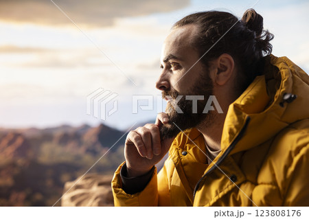 Young traveler enjoys the serenity of the high altitude wilderness, stunning landscape and peaceful surroundings. Nature lover feeling happy climbing to the mountain top, expedition. Young traveler enjoys the serenity of the high altitude wilderness, stunning landscape and peaceful surroundings. Nature lover feeling happy climbing to the mountain top, expedition. 123808176