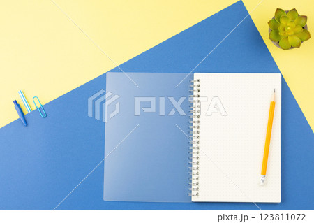 Spiral notepad with pencil on top view table. 123811072
