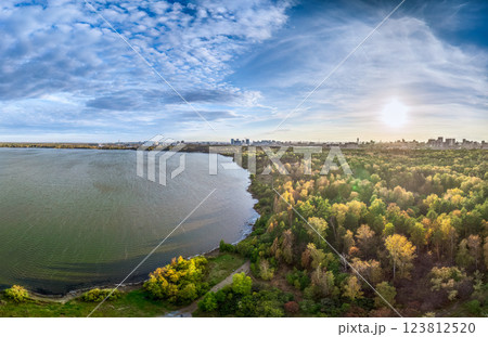Autumn forest on lake shore at sunset and city on horizon, auerial view 123812520