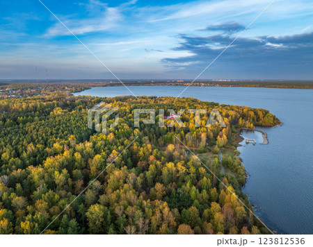 Autumn forest on lake shore at sunset and city on horizon, auerial view 123812536