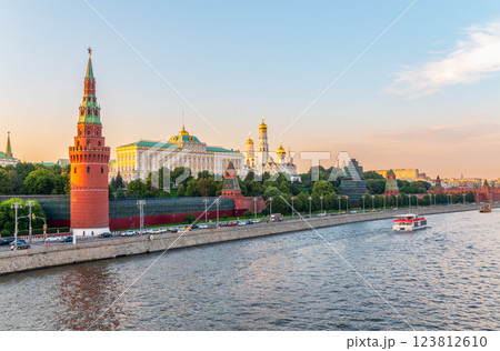 View of Kremlin with Vodovzvodnaya tower, Grand Kremlin Palace from repaired Bolshoy Kamenny Bridge in Moscow city on sunny summer day. Cruise ship sails on the Moscow river 123812610