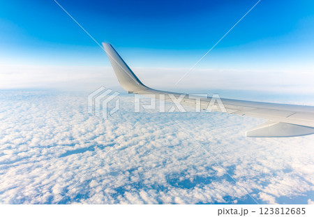 View from the airplane window at a beautiful cloudy sky and the airplane wing 123812685