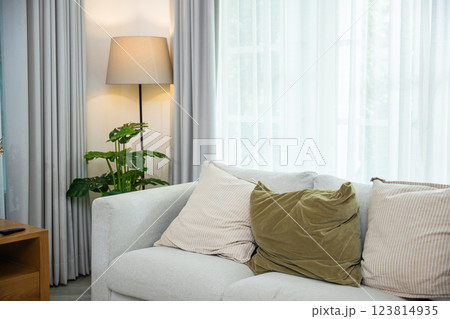 Empty modern living room with a sleek white couch and stylish coffee table, Interior your lifestyle with this versatile modular sectional sofa and the windows have curtains closed, nobody Empty modern living room with a sleek white couch and stylish coffee table, Interior your lifestyle with this versatile modular sectional sofa and the windows have curtains closed, nobody 123814935