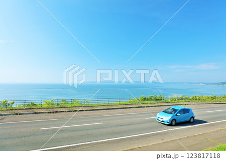 北海道　青空と海沿いの道を走る車 123817118