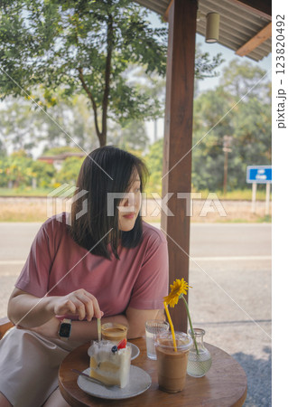 happy and cheerful with asian woman enjoy with coffee and cake in coffee shop happy and cheerful with asian woman enjoy with coffee and cake in coffee shop 123820492