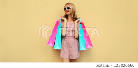 Fashion, clothing. Stylish beautiful happy woman with colorful shopping bags in summer dress Fashion, clothing. Stylish beautiful happy woman with colorful shopping bags in summer dress 123820660