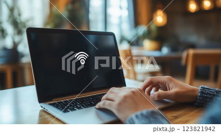 A person using a laptop in a cafe encounters a No Internet connection error, highlighting network connectivity issues. 123821942