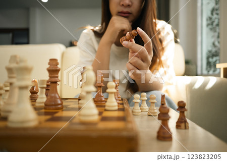 Cropped shot of woman holding a chess piece, contemplating the next chess move 123823205