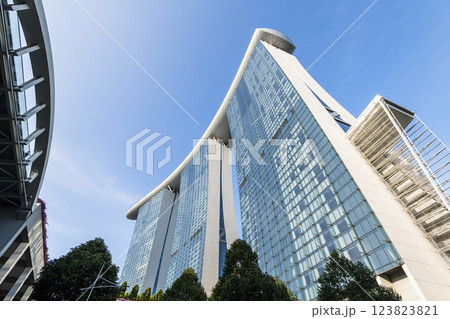 Building view of the Marina Bay Sands Hotel, Singapore, includes three towers topped by the Sands Skypark, a skyway, and an infinity-edge swimming pool.  123823821