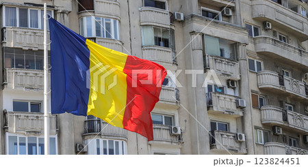 Romanian flag waving proudly in Bucharest against a backdrop of residential buildings during a sunny day 123824451