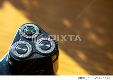 A detailed close up showcasing a shaver that has three razor blades 123825358
