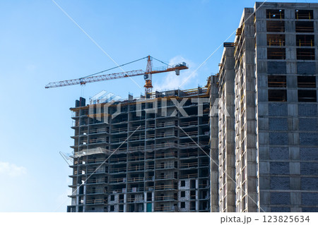 A busy construction site with cranes and a building in progress A busy construction site with cranes and a building in progress 123825634