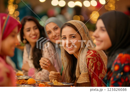 Group of young Muslim women are happily enjoying a meal together in a restaurant, celebrating their friendship and cultural traditions Group of young Muslim women are happily enjoying a meal together in a restaurant, celebrating their friendship and cultural traditions 123826086