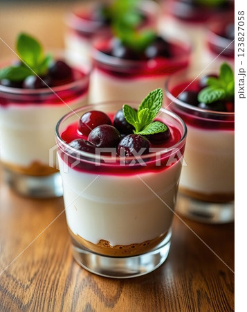 Elegant Dual-Layered Berry and Vanilla Panna Cotta Individual Dessert Cups with Fresh Mint Garnish in Contemporary Presentation 123827058