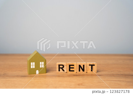 Real estate, apartment and housing rental concept. Miniature house and wooden blocks with inscription Rent Real estate, apartment and housing rental concept. Miniature house and wooden blocks with inscription Rent 123827178