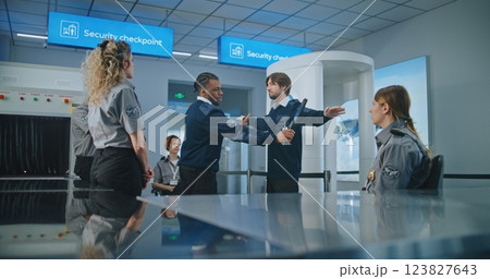 TSA Officer Demonstrating Process of Scanning Passengers with Metal Detector to Workers TSA Officer Demonstrating Process of Scanning Passengers with Metal Detector to Workers 123827643