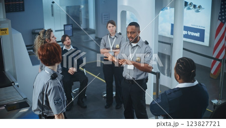 TSA Officer Holding Briefing, Providing Instruction to Team of Workers About Scanning Procedures 123827721