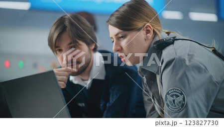 Airport Security Checkpoint: Close Up of Two Diverse Security Officers Using Laptop and Talking Airport Security Checkpoint: Close Up of Two Diverse Security Officers Using Laptop and Talking 123827730